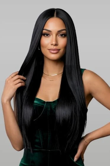 Woman with long black hair wearing a green dress against a gray background