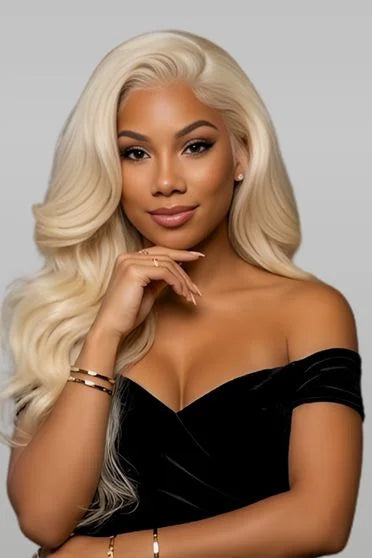 Woman with blonde hair wearing a black off-shoulder top against a gray background