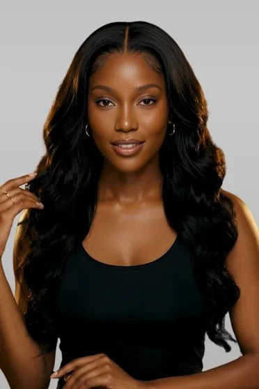 Woman with long, wavy black hair against a gray background